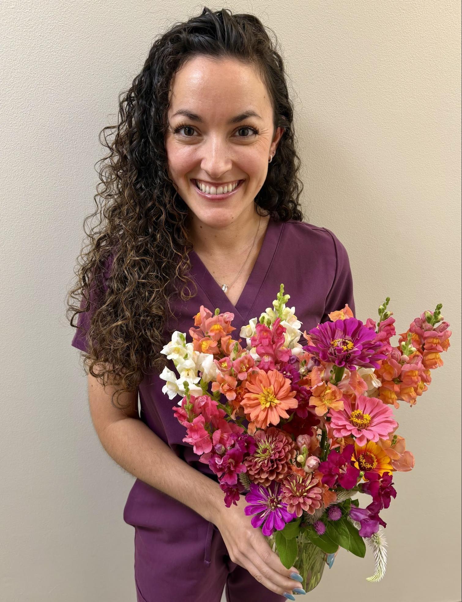 Dr. McArdle holding a bouquet of flowers.